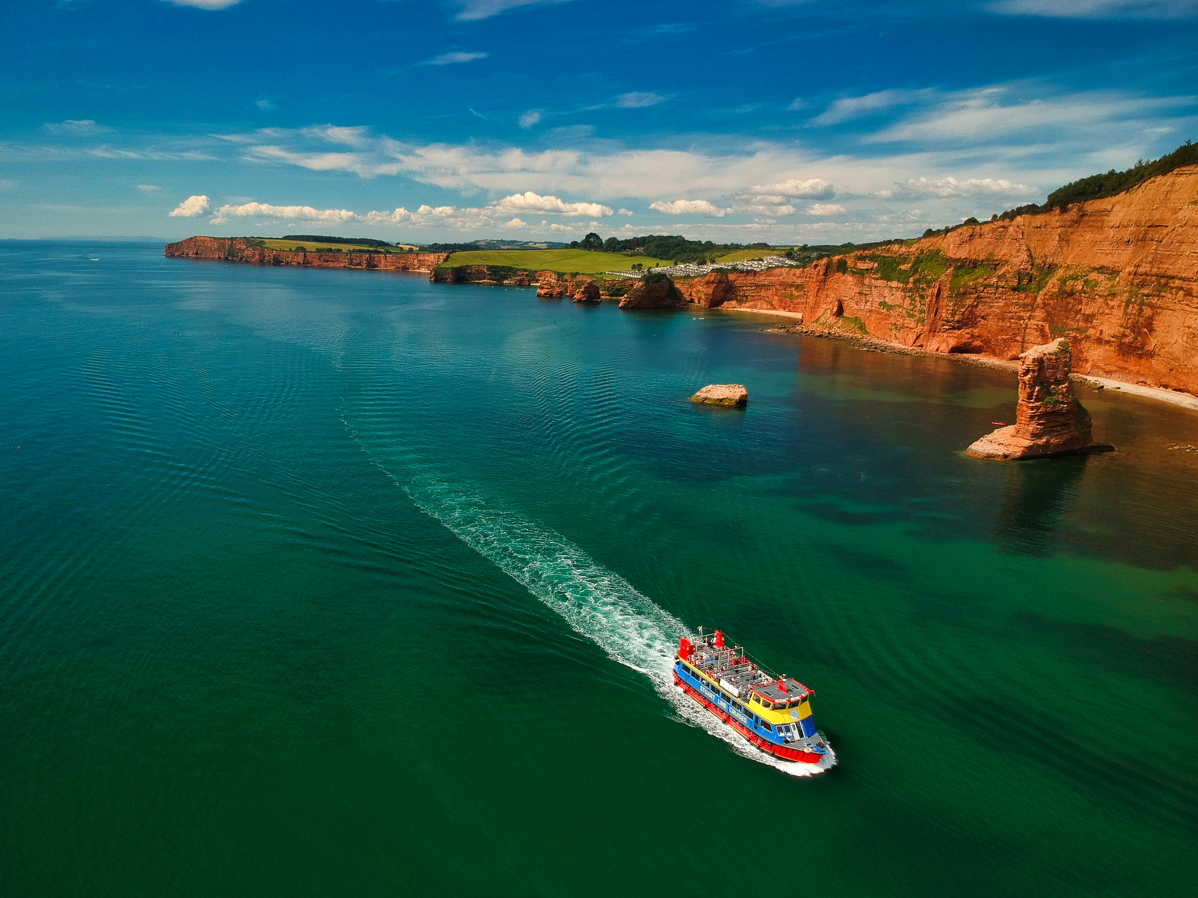 white and red boat on sea during daytime